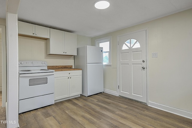 kitchen featuring white appliances, white cabinetry, light hardwood / wood-style flooring, and butcher block counters