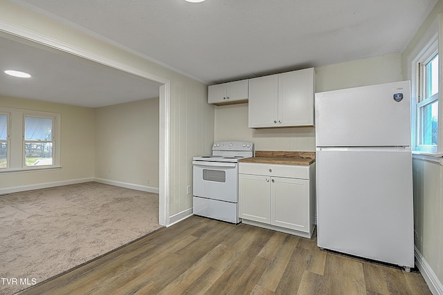 kitchen featuring white cabinets, light hardwood / wood-style floors, and white appliances