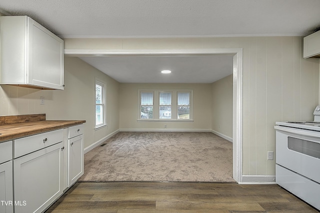 unfurnished dining area with wood-type flooring, a textured ceiling, and wooden walls