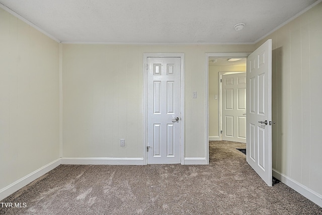 carpeted empty room featuring a textured ceiling and ornamental molding