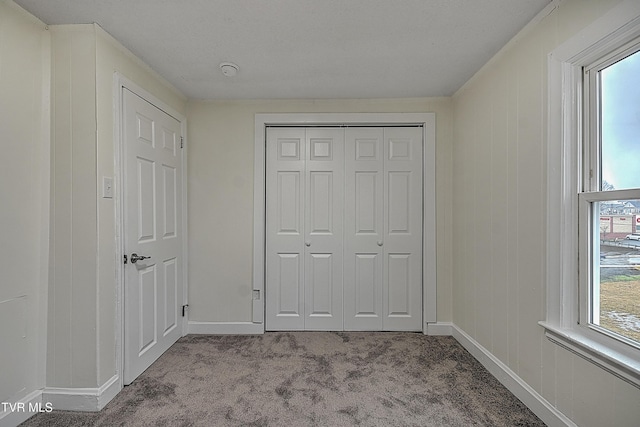 unfurnished bedroom featuring light carpet and a closet