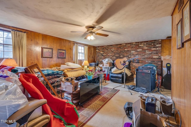 interior space featuring ceiling fan, brick wall, a wood stove, and wooden walls