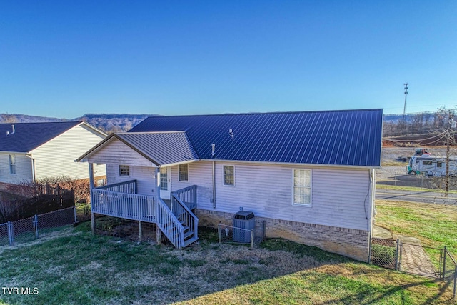 back of house featuring a lawn and a wooden deck