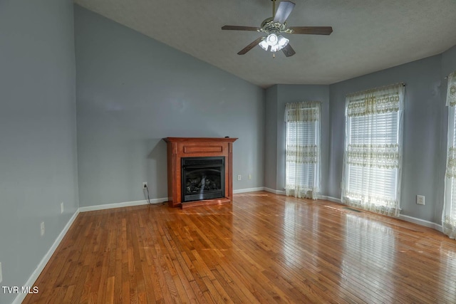 unfurnished living room with ceiling fan, light hardwood / wood-style flooring, and a textured ceiling