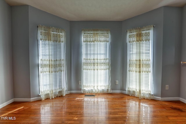 spare room featuring a textured ceiling and light wood-type flooring