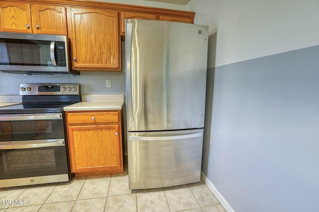 kitchen featuring light tile patterned floors and stainless steel appliances