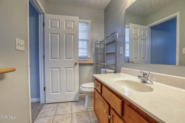 bathroom featuring tile patterned floors, vanity, toilet, and a textured ceiling