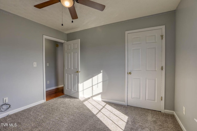 unfurnished bedroom featuring carpet, ceiling fan, and a textured ceiling