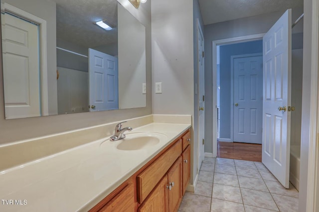 bathroom with tile patterned floors, vanity, a textured ceiling, and shower with separate bathtub