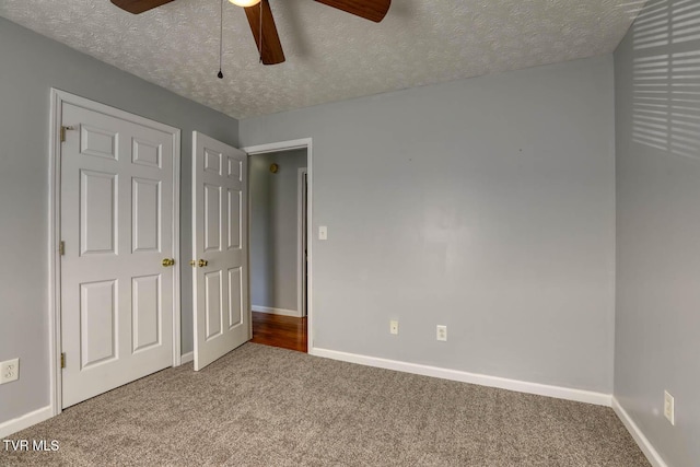 unfurnished bedroom featuring ceiling fan, carpet floors, and a textured ceiling