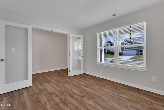 spare room featuring hardwood / wood-style floors, plenty of natural light, and french doors