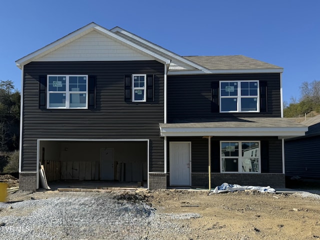 view of front of house featuring a porch, an attached garage, and driveway