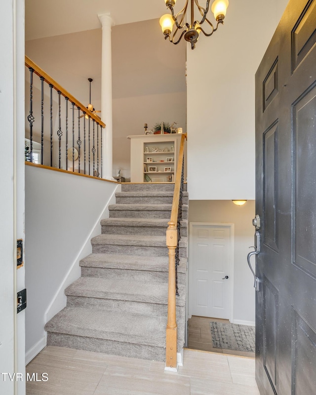 stairway with a chandelier and a high ceiling