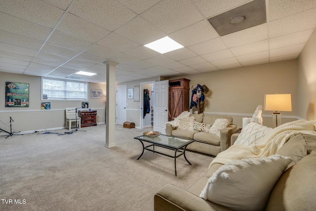 living room featuring light carpet and a drop ceiling