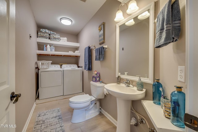 bathroom with hardwood / wood-style flooring, washer and clothes dryer, and toilet