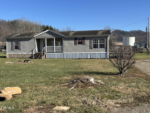 manufactured / mobile home featuring covered porch and a front yard