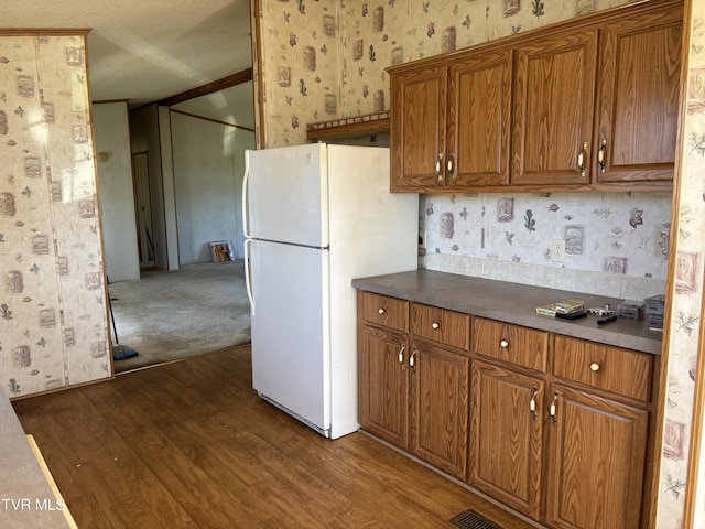 kitchen featuring white fridge and dark wood-type flooring