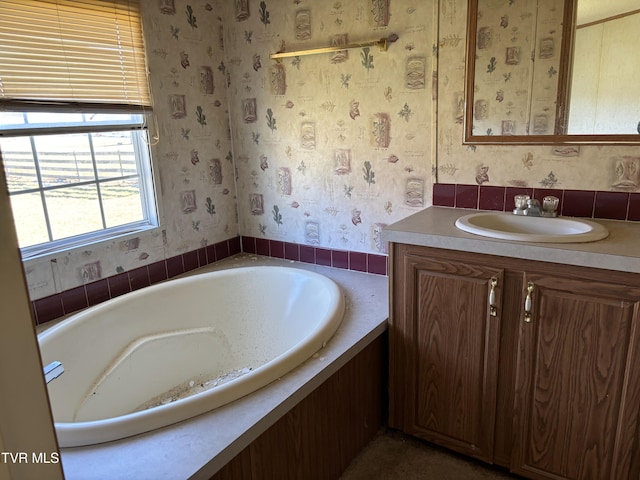 bathroom with a washtub and vanity