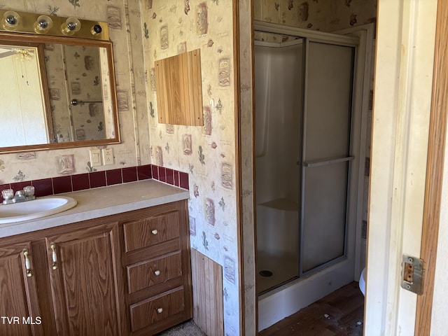 bathroom with vanity and a shower with door