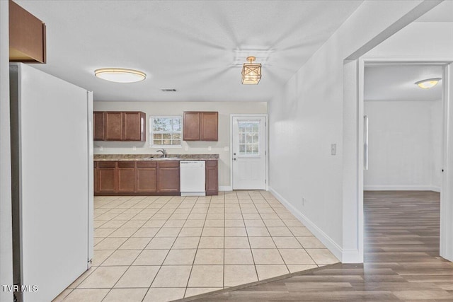 kitchen with sink, white appliances, and light hardwood / wood-style flooring