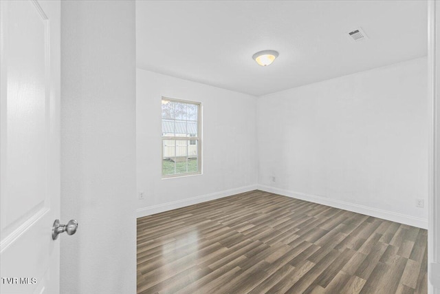 unfurnished room with dark hardwood / wood-style flooring