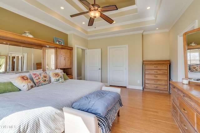 bedroom with light wood-type flooring, ornamental molding, a raised ceiling, and recessed lighting