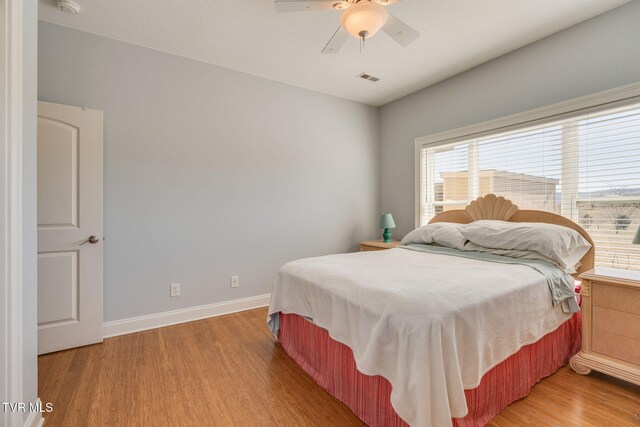 bedroom with light wood-type flooring, visible vents, baseboards, and a ceiling fan