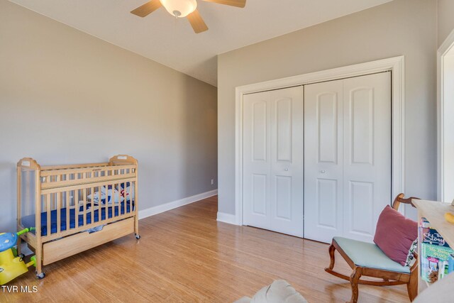 bedroom featuring ceiling fan, wood finished floors, baseboards, vaulted ceiling, and a closet