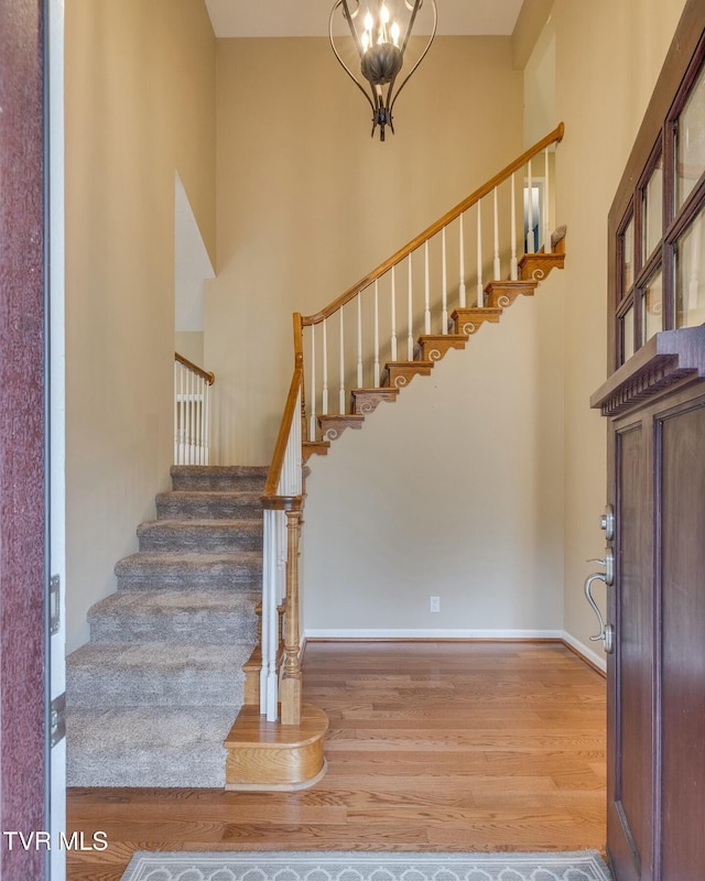 foyer entrance with a chandelier, a high ceiling, and light hardwood / wood-style flooring