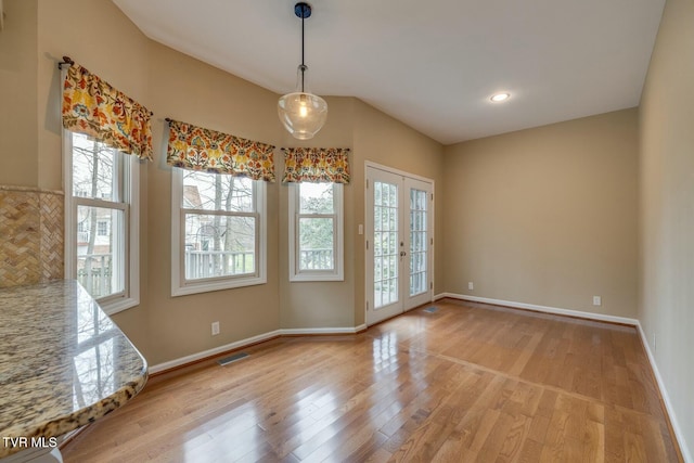 spare room with french doors and light wood-type flooring