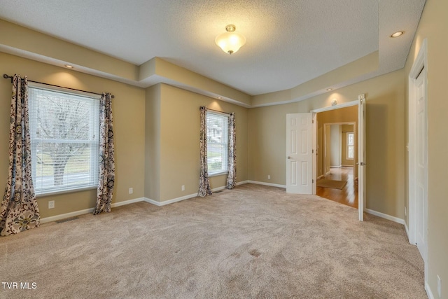 unfurnished bedroom featuring light colored carpet and a textured ceiling