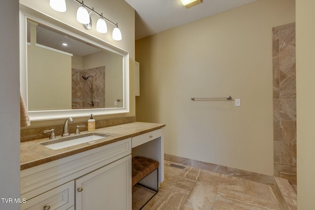 bathroom featuring a shower and vanity