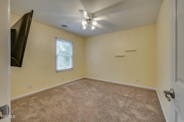 spare room featuring light carpet and ceiling fan