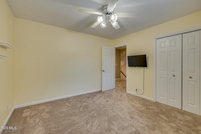 unfurnished bedroom featuring a closet, ceiling fan, and light colored carpet