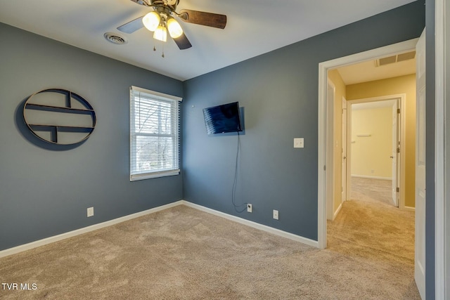 spare room with ceiling fan and light colored carpet