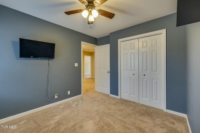 unfurnished bedroom featuring ceiling fan, a closet, and light carpet