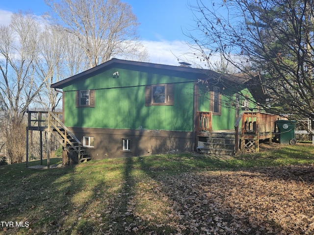 view of side of home with a yard and a deck