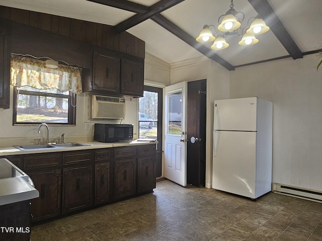 kitchen with dark brown cabinets, a wall unit AC, sink, a notable chandelier, and white fridge