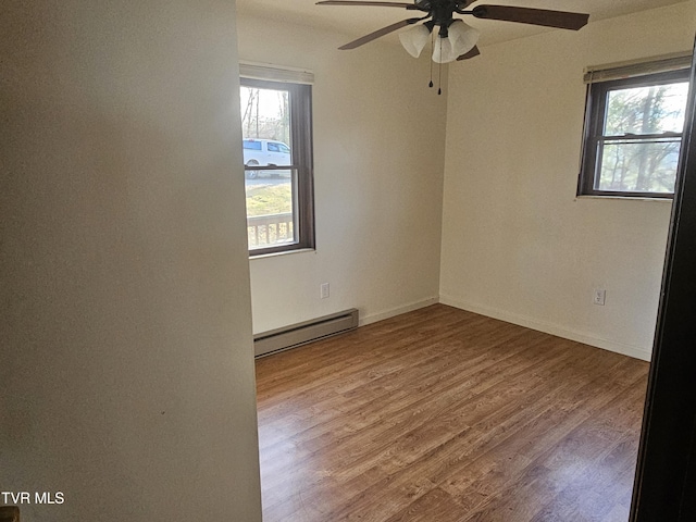 unfurnished room featuring hardwood / wood-style flooring, ceiling fan, and a baseboard radiator