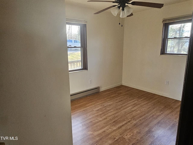 spare room with hardwood / wood-style flooring, ceiling fan, and a baseboard radiator