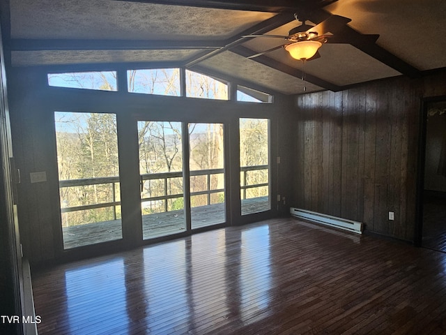 unfurnished room featuring wood walls, ceiling fan, dark hardwood / wood-style floors, and a baseboard heating unit