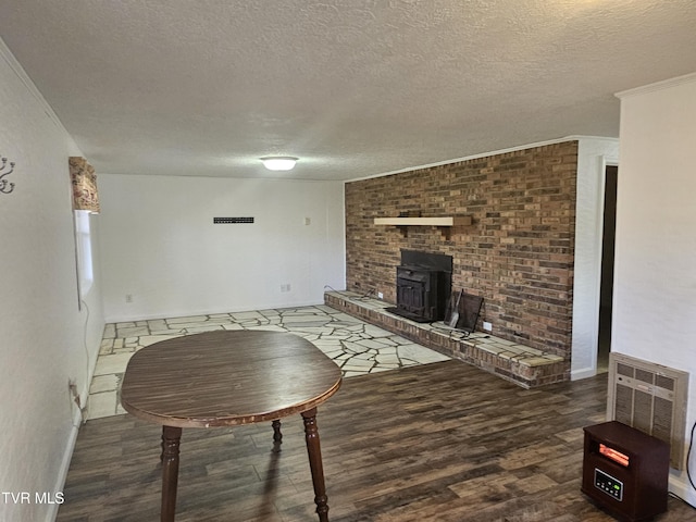 unfurnished living room featuring crown molding, dark hardwood / wood-style flooring, a wood stove, and a textured ceiling