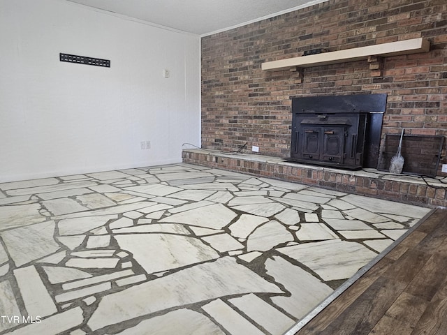 unfurnished living room with a wood stove, brick wall, and ornamental molding