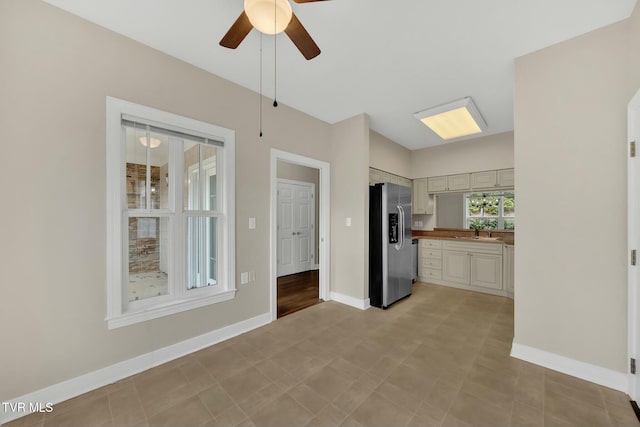 kitchen featuring stainless steel refrigerator with ice dispenser, ceiling fan, and sink