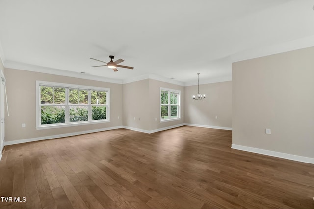 empty room featuring ceiling fan with notable chandelier, dark hardwood / wood-style flooring, and ornamental molding