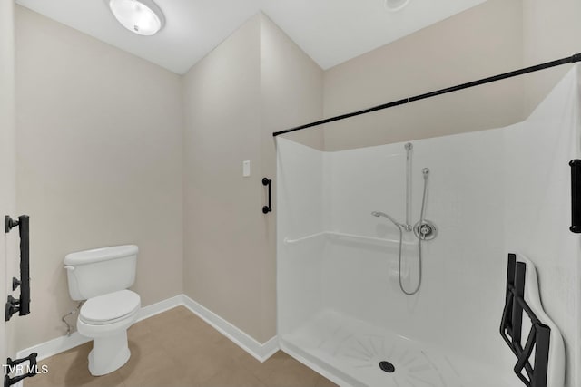 bathroom featuring tile patterned floors, toilet, and walk in shower