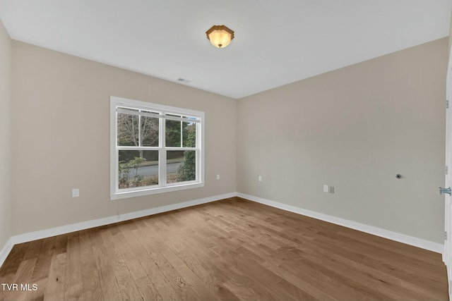 unfurnished room with hardwood / wood-style flooring