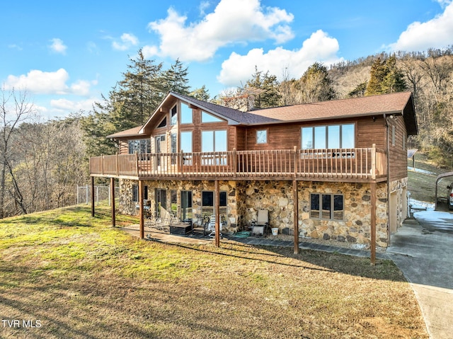 back of house featuring a wooden deck, a lawn, and a patio area