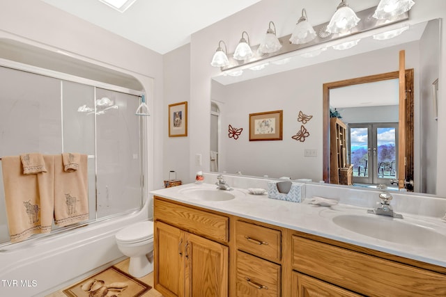 full bathroom with toilet, vanity, and shower / bath combination with glass door