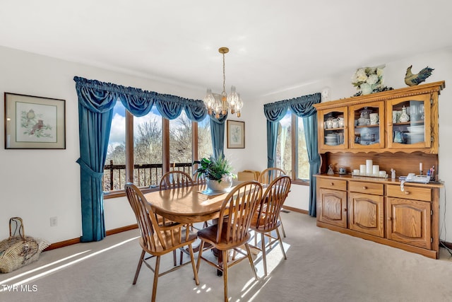 dining area featuring light carpet and a notable chandelier